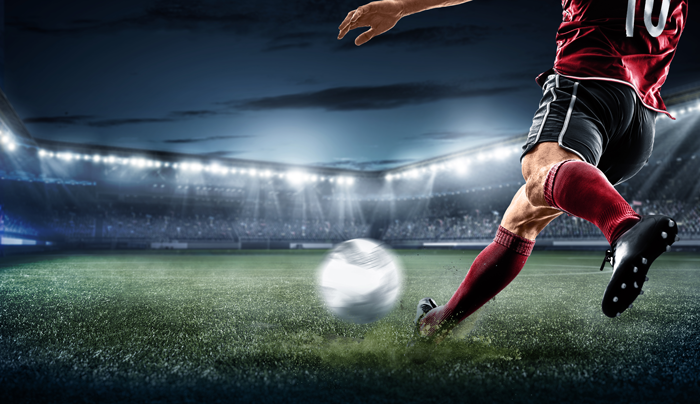 soccer player about to kick a ball in a stadium